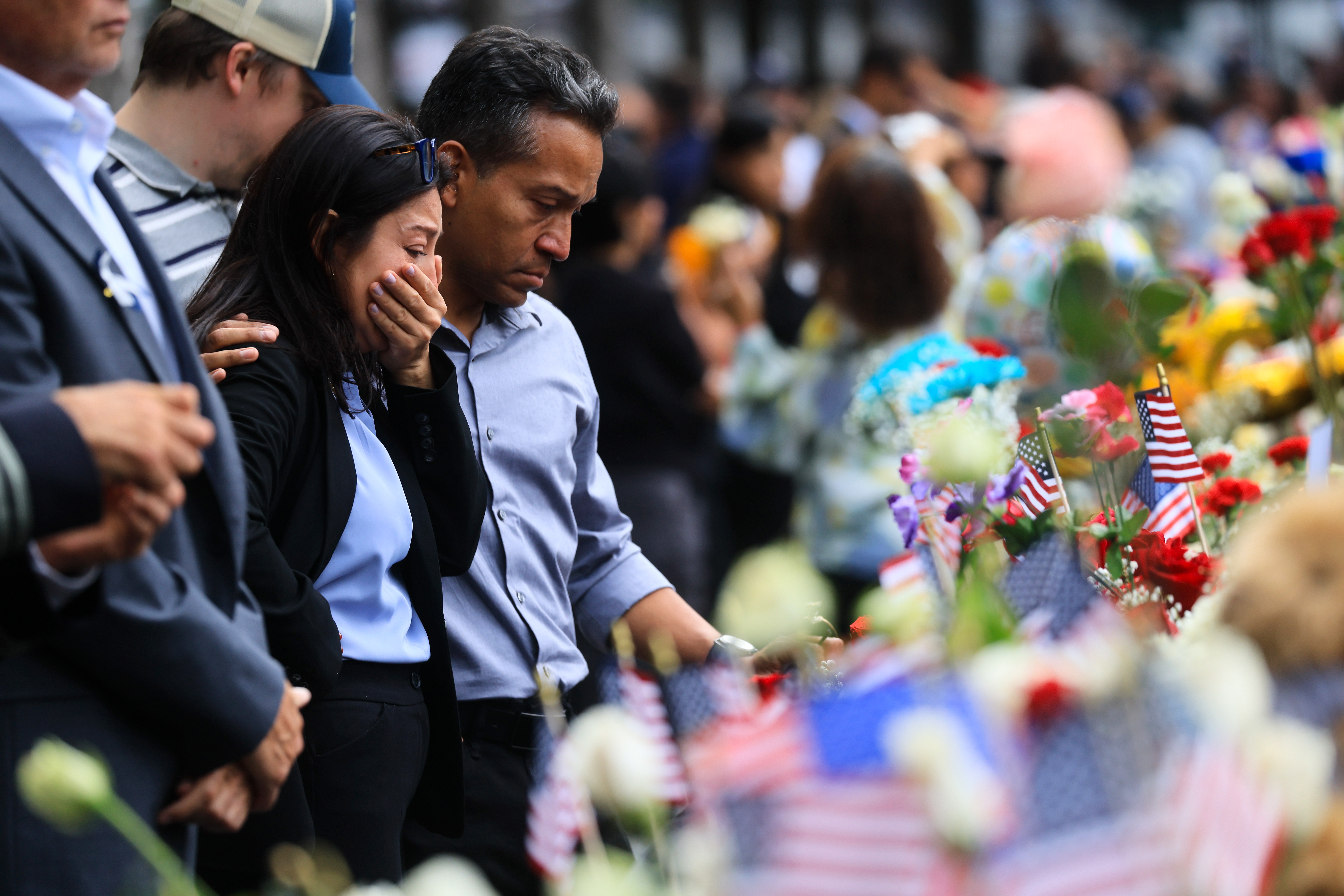 People pause as they stand at the memorial during a ceremony commemorating the 25th anniversary of the September 11th terrorist attacks on the World Trade Center at the National 9/11 Memorial & Museum on September 11, 2026 in New York City.